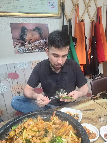 오리고기를 쌈에 싸서 먹는 모습