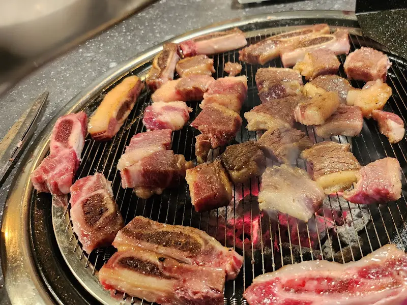 숯불 위에서 익어가는 생갈비 조각들