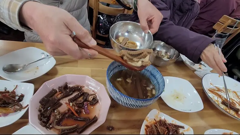 버섯두부전골을 개인 그릇에 담는 모습