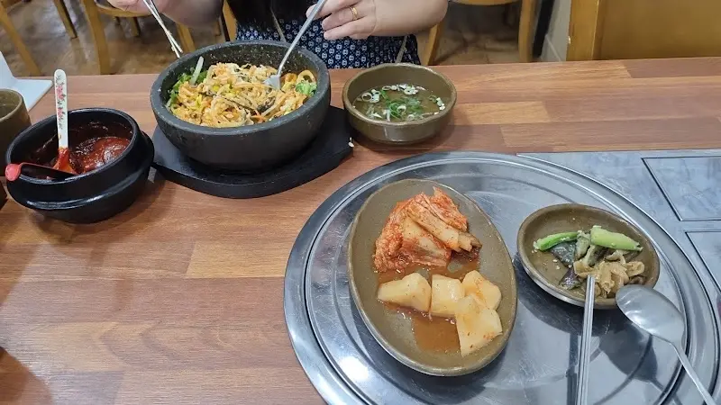 돌솥비빔밥과 반찬이 차려진 테이블