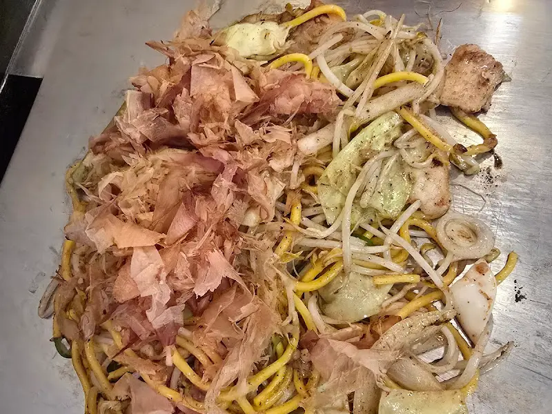 철판 위에서 조리 중인 야끼소바 재료들