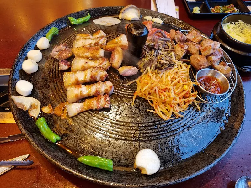 솥뚜껑 위에서 맛있게 익어가는 목살과 각종 채소들