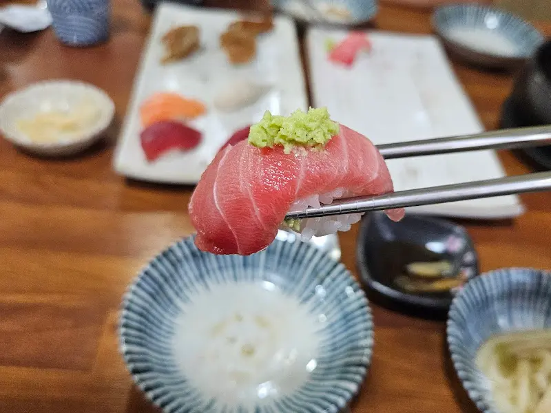 젓가락으로 집어 올린 참치 초밥