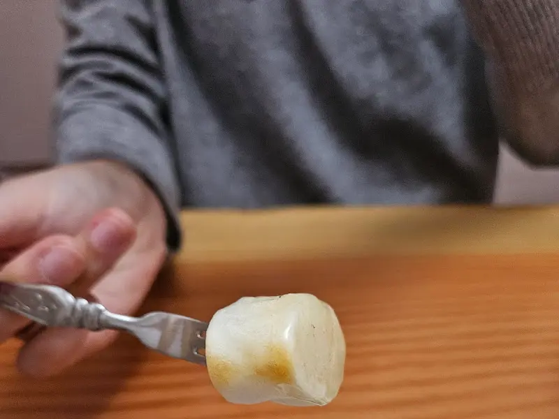 꿀에 찍은 가래떡을 포크로 찍어올리는 모습