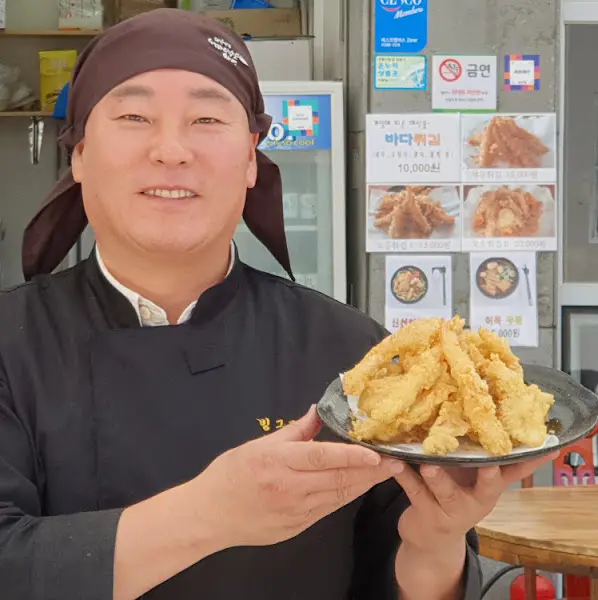 싱싱한 해산물을 들고 환하게 웃는 사장님