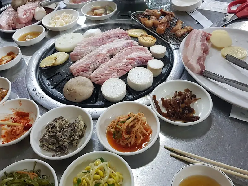 불판 가득찬 삼겹살과 곁들임