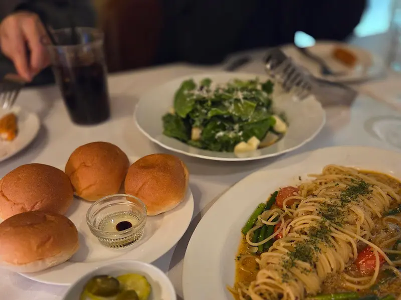 샐러드와 파스타, 식전빵이 함께 놓인 테이블