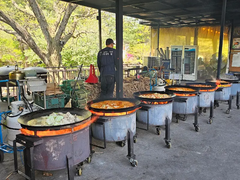 솥뚜껑들이 줄지어 늘어서 있는 야외 조리 공간