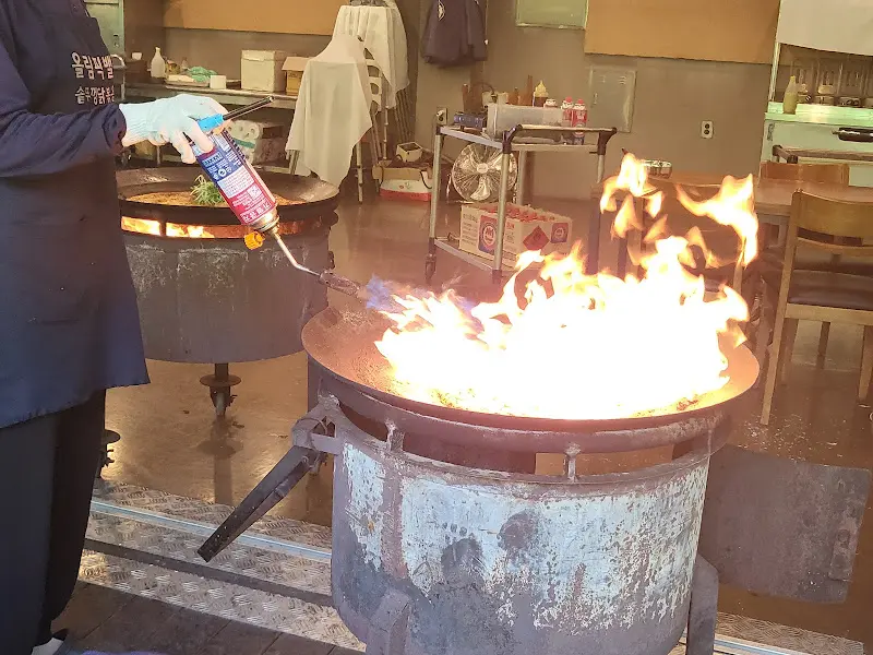 직원이 토치로 볶음밥을 굽는 모습
