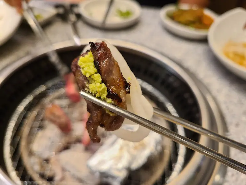 잘 익은 갈비를 젓가락으로 집어 올린 모습