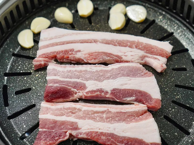 불판 위에 올려진 약돌 삼겹살