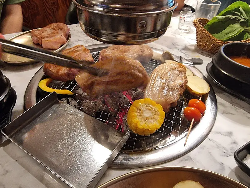 숯불 위에서 익어가는 삼겹살과 막창