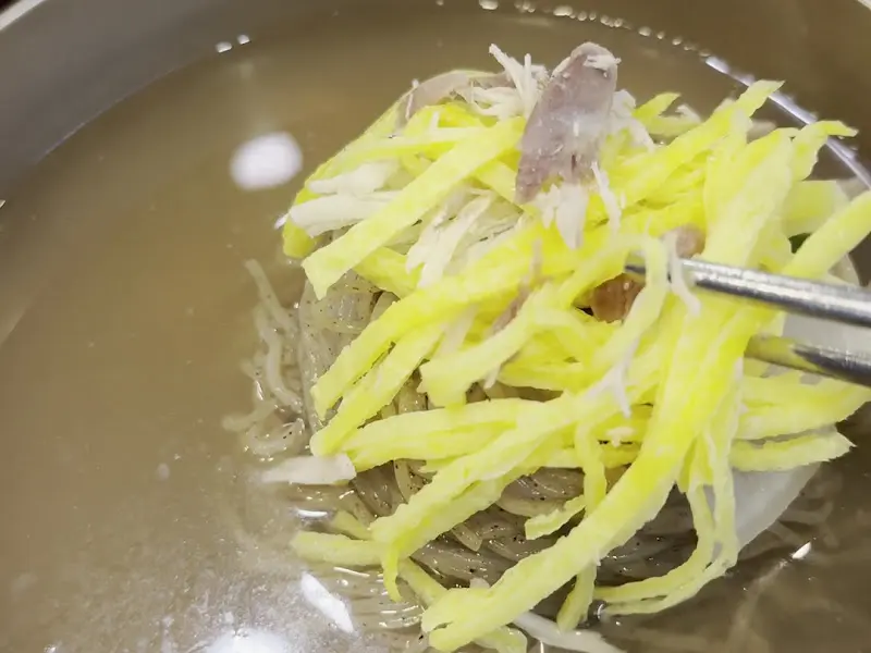 젓가락으로 든 꿩냉면