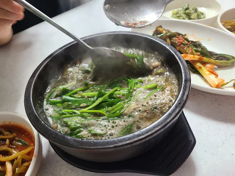 뜨거운 뚝배기 안에서 끓고 있는 꼬막 된장국