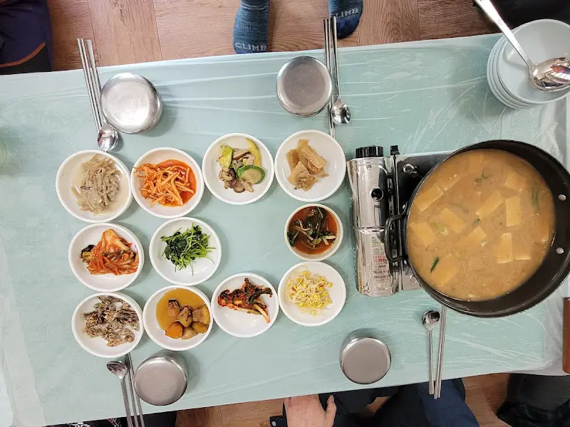 청국장찌개와 12가지 반찬이 차려진 테이블
