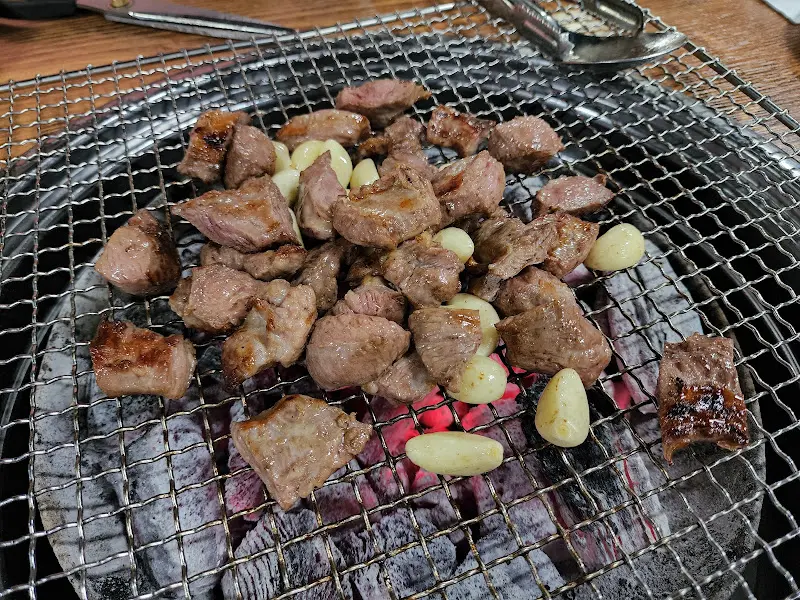 숯불 위에서 구워지는 갈매기살과 마늘