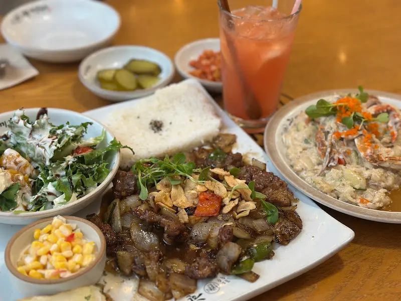 스테이크와 필라프, 샐러드, 음료의 푸짐한 한 상 차림