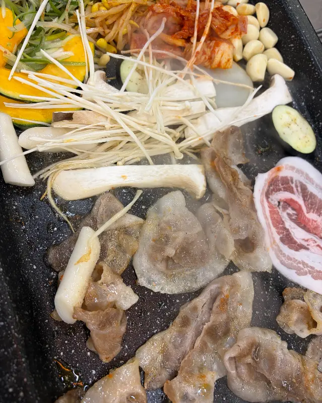 불판 위에 구워진 고기와 야채들