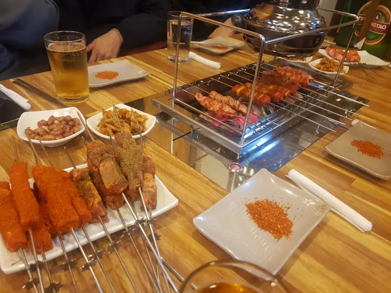 테이블 위에서 맛있게 구워지고 있는 양꼬치의 모습