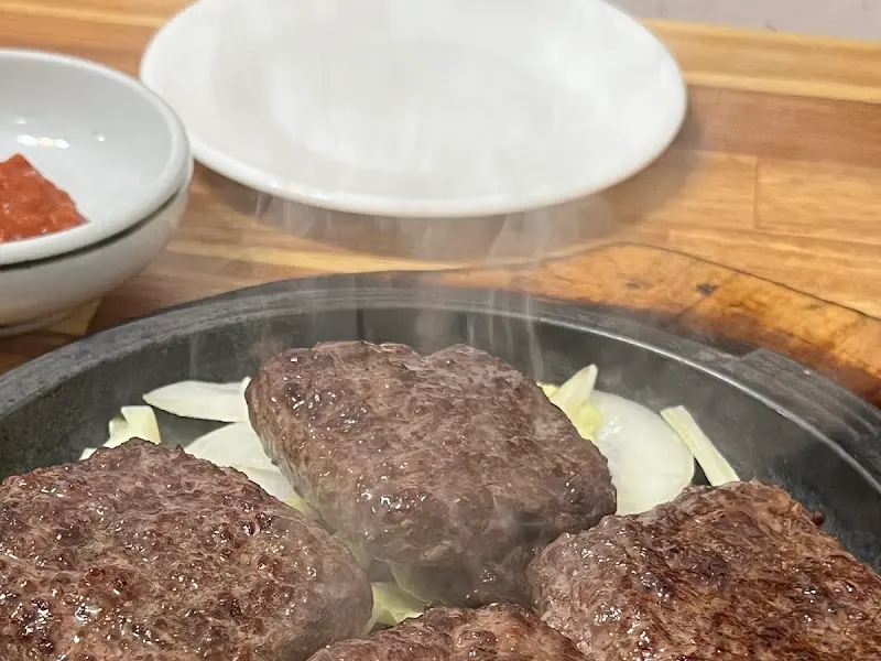 뜨거운 철판 위에서 김이 모락모락 나는 떡갈비