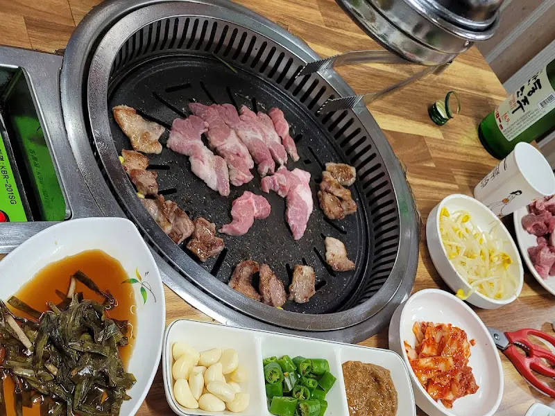 불판 위에 올려진 뒷고기와 다양한 반찬들