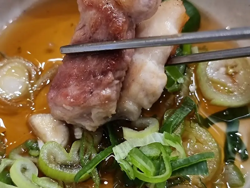 육즙 가득한 돼지고기를 소스에 찍어먹는 모습