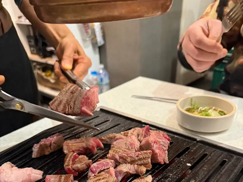 잘 구워진 고기를 먹기 좋게 잘라주는 모습