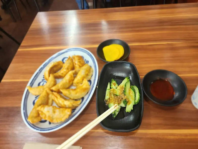 덕천손만두에서 군만두와 오이, 단무지, 간장 소스를 함께 즐기는 모습