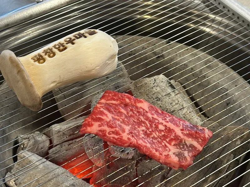 숯불 위에 구워지는 한우와 버섯