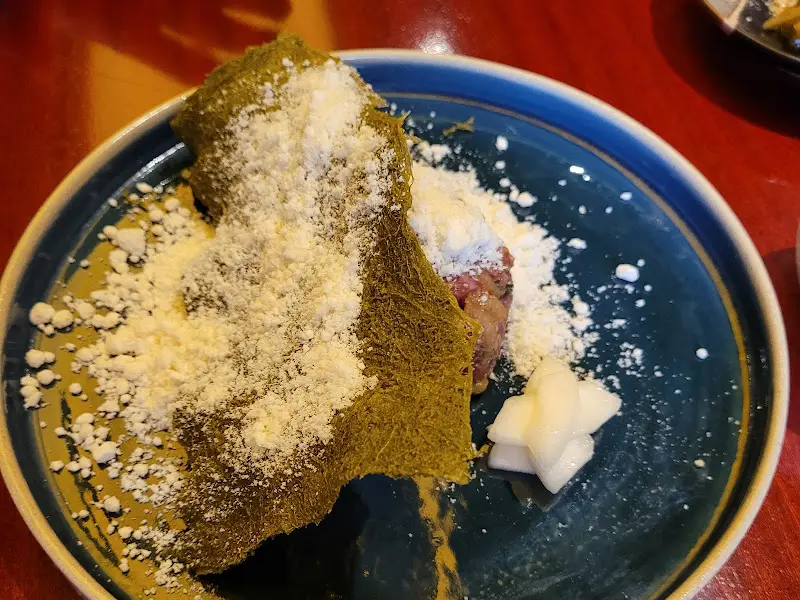 녹색 잎과 하얀 가루가 뿌려진 요리