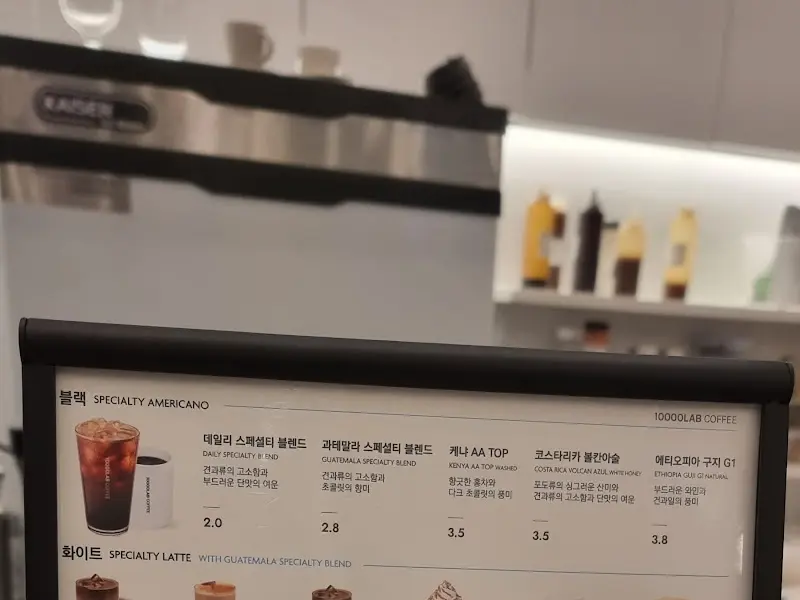 커피 머신과 메뉴 안내판이 있는 카운터 공간.
