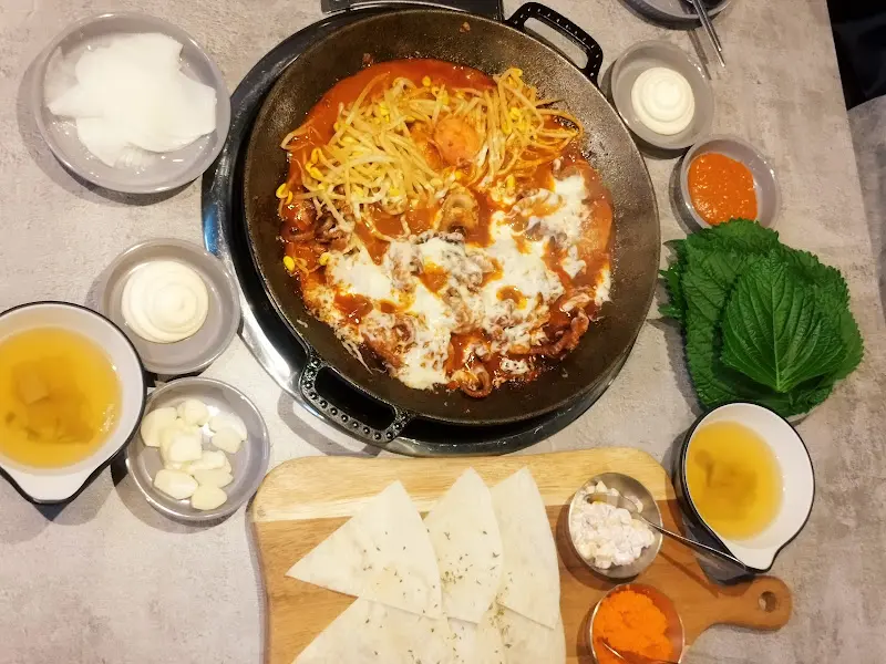 쭈꾸미 삼겹살과 냉탱면이 함께 차려진 푸짐한 한 상