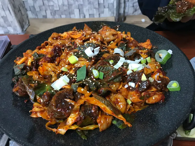 곱창볶음을 상추에 싸서 먹는 모습