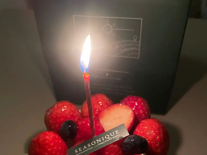 초가 켜진 딸기 와르르 케이크와 선물 상자