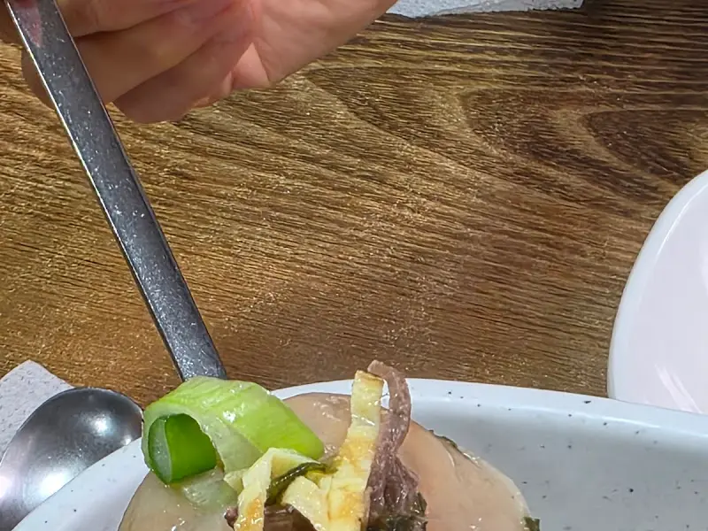 김치만두국의 만두를 들어올리는 모습