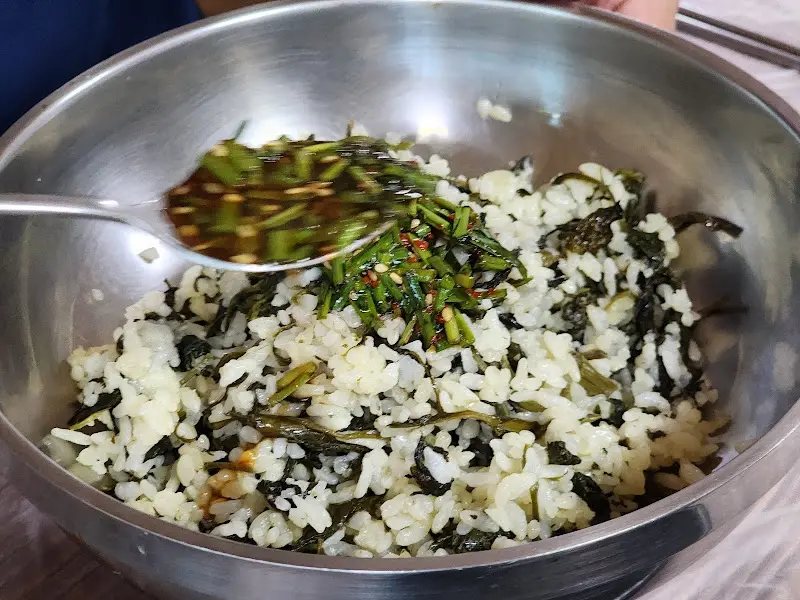 곤드레밥에 양념장을 넣어 비비는 모습