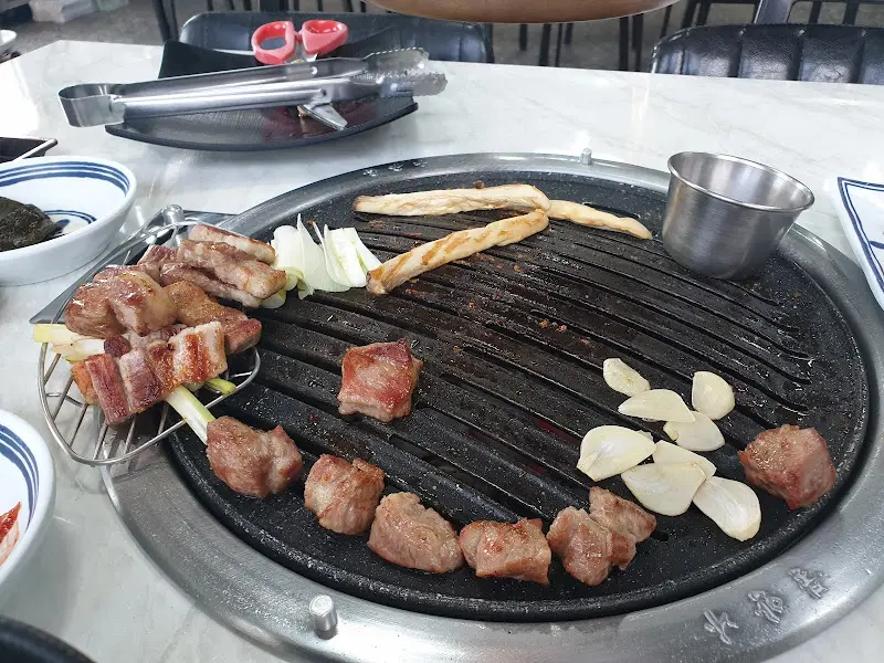 불판 위에서 맛있게 구워지는 삼겹살과 마늘
