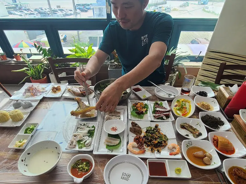 푸짐한 한 상 차림 앞에서 행복한 미소를 짓는 손님