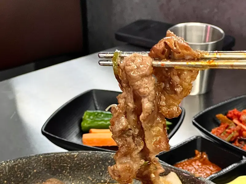 우삼겹을 젓가락으로 집은 모습