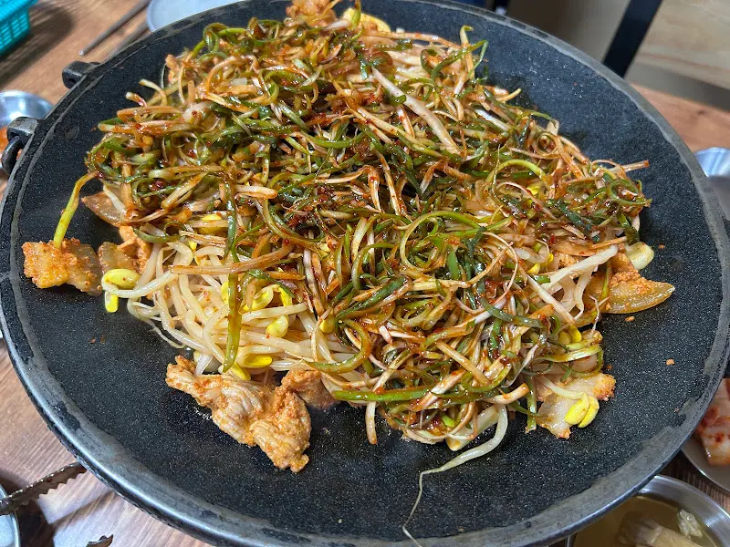 흑돼지 두루치기에 야채를 듬뿍 올려 볶는 모습