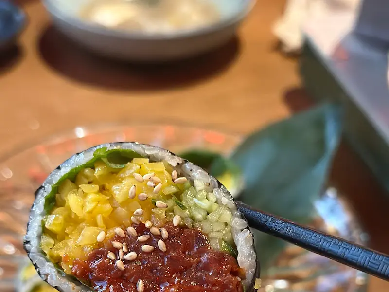 젓가락으로 육회김밥을 들어올린 모습