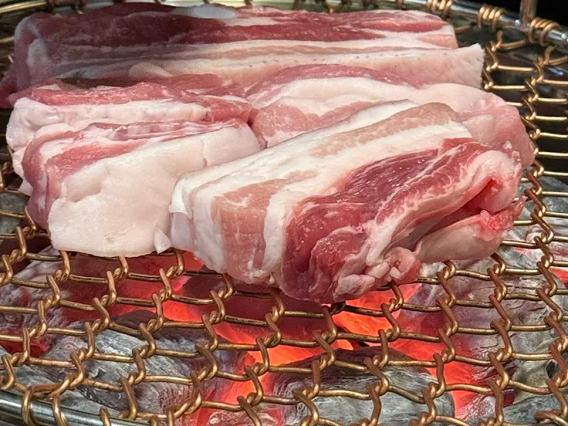 숯불 위에서 노릇하게 익어가는 흑돼지