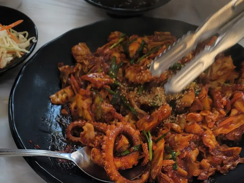 집게로 낙지볶음을 들어올리는 모습