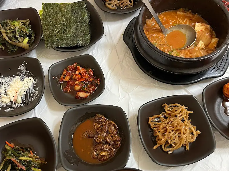 다양한 종류의 밑반찬과 찌개가 놓여있는 테이블