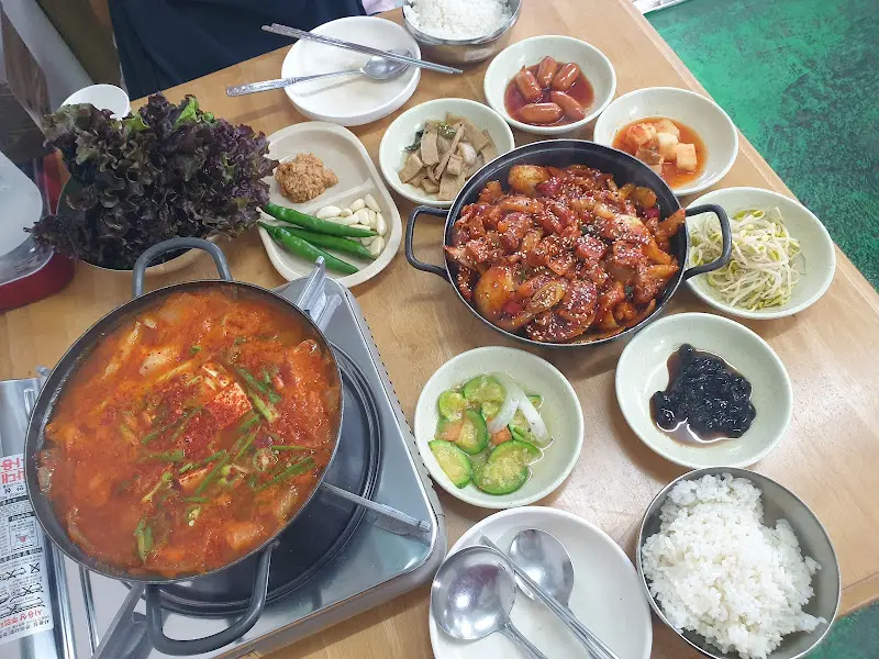 두루치기와 김치찌개, 다양한 밑반찬이 한 상 가득 차려진 모습