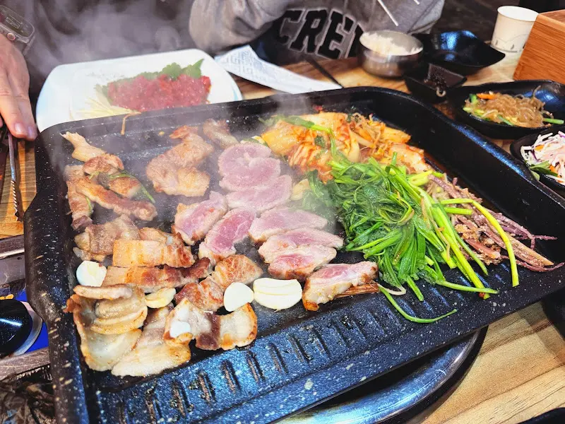 돌판에 구워진 삼겹살과 미나리