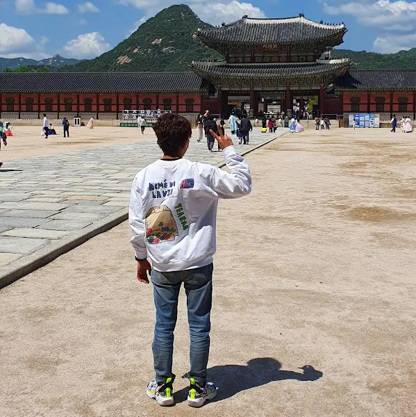 경복궁 앞에서 브이 포즈를 취한 사람