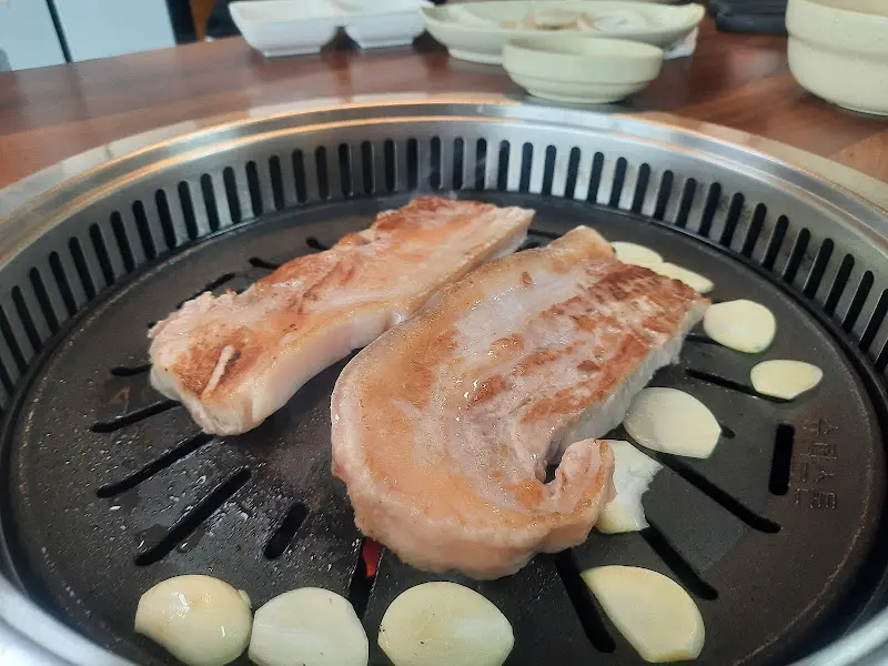 불판 위에서 맛있게 익어가는 흑돼지 삼겹살