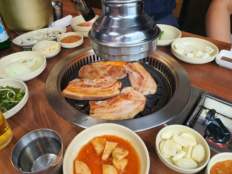 숯불 위에서 구워지는 흑돼지 삼겹살과 마늘