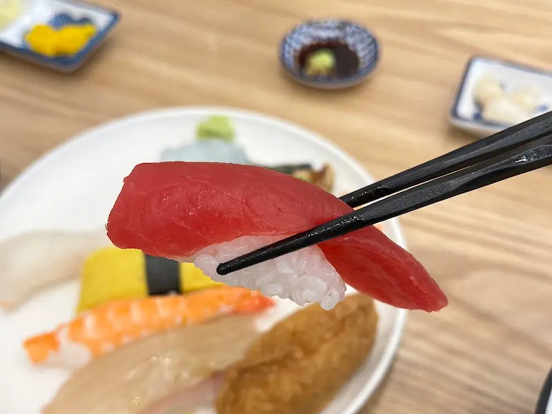 젓가락으로 집어 올린 참치 초밥